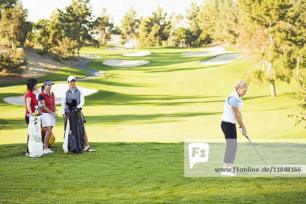 Women playing golf on golf course