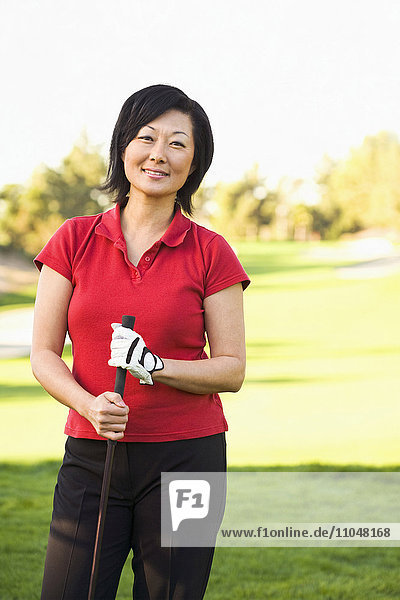 Koreanische Frau spielt Golf auf dem Golfplatz
