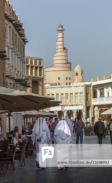 Men walking on Doha street  Doha  Qatar