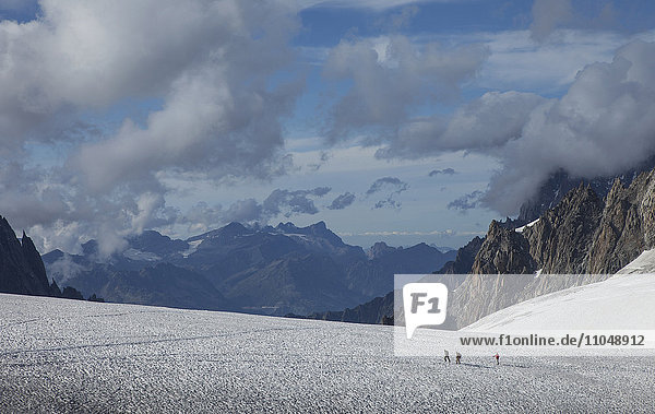 Hikers walking on glacier in remote landscape