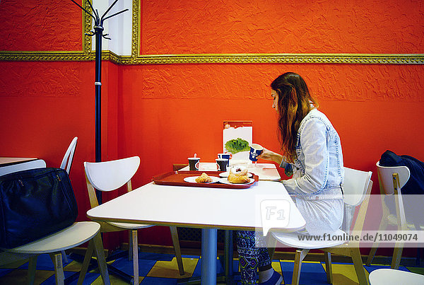 Kaukasische Frau beim Essen im Restaurant