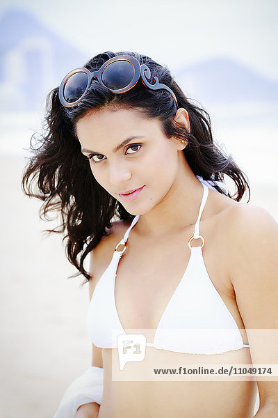 Hispanische Frau im Bikini am Strand