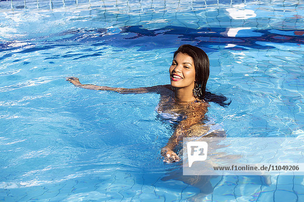 Hispanische Frau schwimmt im Pool