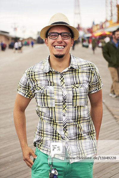 Hispanischer Mann lächelnd auf der Promenade