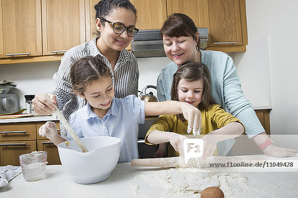 Mütter bringen Töchtern in der Küche das Backen bei