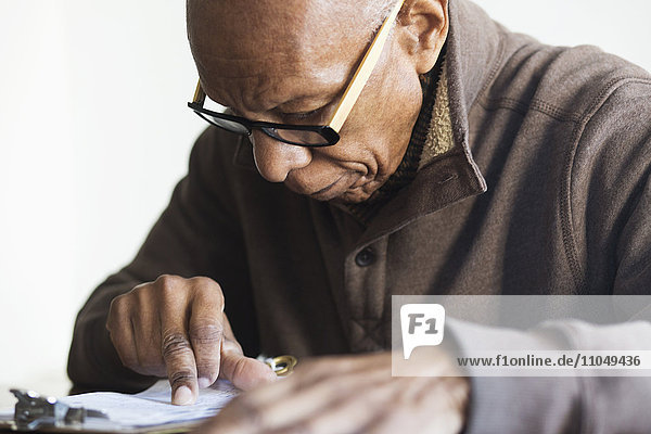 Älterer schwarzer Mann liest Notizen