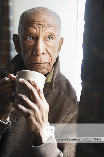 Älterer schwarzer Mann trinkt eine Tasse Kaffee