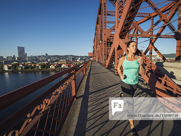 Kaukasische Frau beim Joggen auf einer Brücke  Portland  Oregon  Vereinigte Staaten