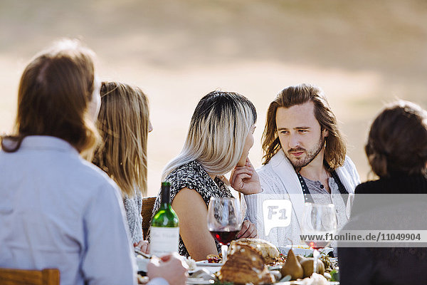 Freunde essen am Tisch im Freien
