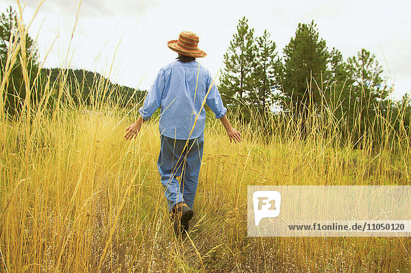 Japanese woman walking in field of tall grass