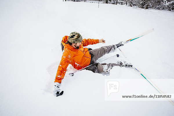 Kaukasischer Mann stürzt auf Langlaufskiern im Schnee