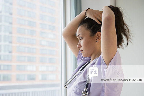 Krankenschwester bindet ihr Haar im Krankenhaus hoch