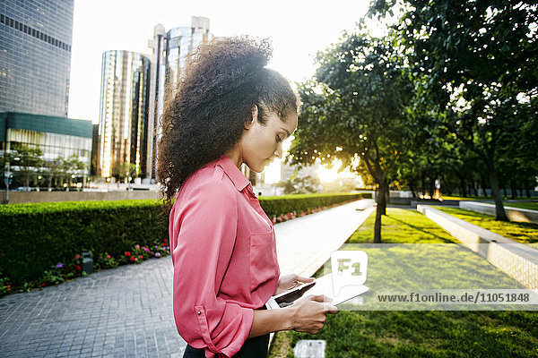 Hispanic businesswoman using digital tablet outdoors