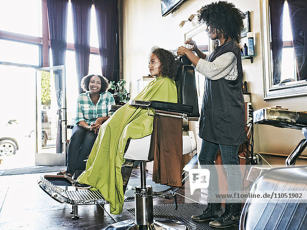 Lächelnde Friseurin und Kunden im Friseursalon