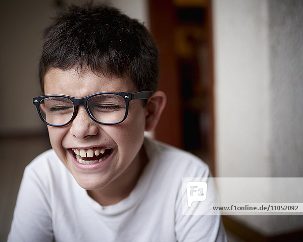 Laughing Hispanic boy wearing eyeglasses