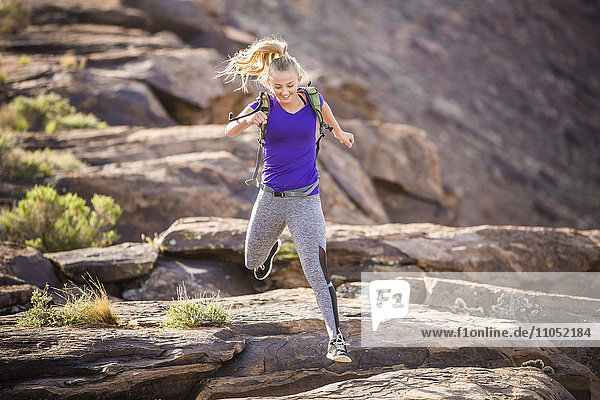 Caucasian woman running on rock formation
