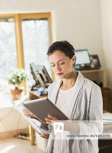 Frau benutzt digitales Tablet im Büro