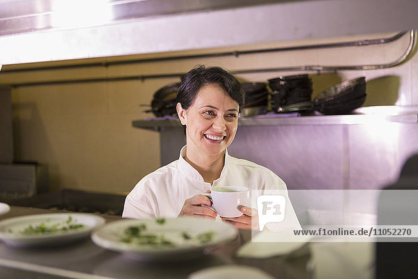 Kaukasischer Koch lächelnd in Restaurantküche
