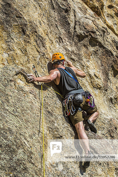 Caucasian man climbing rock