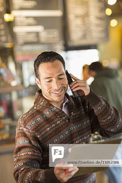 Hispanic businessman talking on telephone in coffee shop