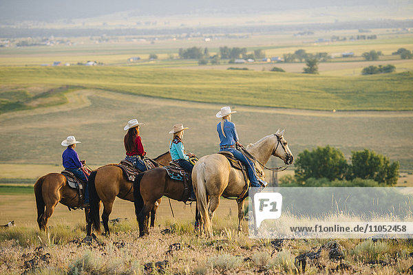 Cowboy und Cowgirls auf dem Pferderücken bewundern ländliche Landschaft