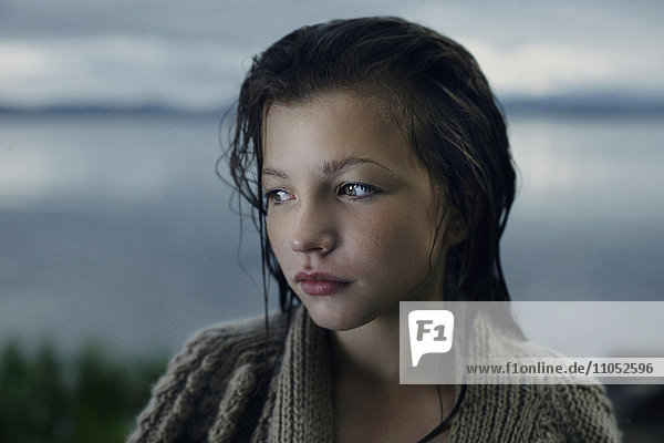 Nachdenkliches kaukasisches Mädchen mit nassen Haaren am See