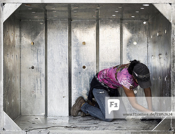 Worker examining metal walls