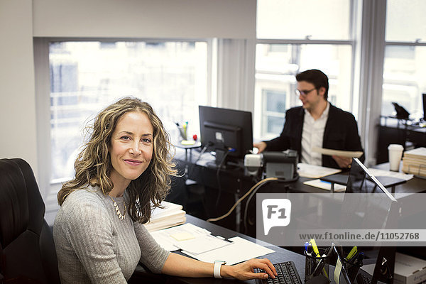 Caucasian businesswoman smiling in office
