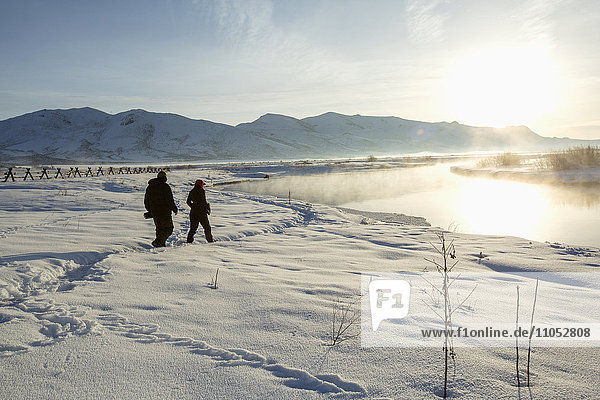 Kaukasisches Paar geht in verschneiter Landschaft spazieren