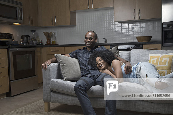 African American couple relaxing on sofa