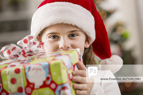 Kaukasisches Mädchen hält Weihnachtsgeschenk