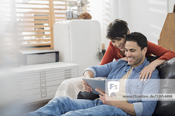 Ein Paar  Mann und Frau  die ein digitales Tablett benutzen.