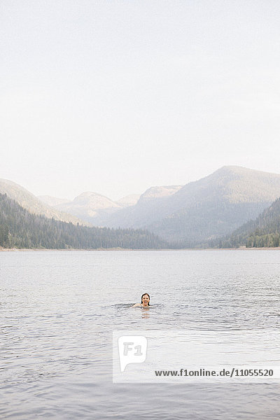 A woman swimming in the waters of a lake.