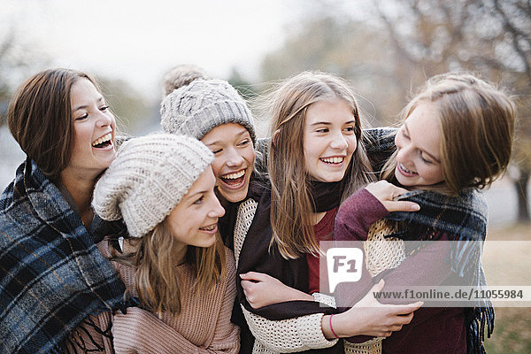 Fünf junge Leute  Mädchen  Freunde in warmen Schals und Wollmützen im Freien.