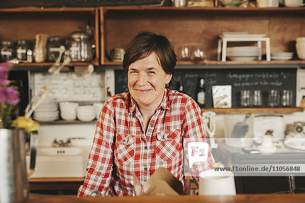 A woman working behind the counter in a coffee shop. Business owner.