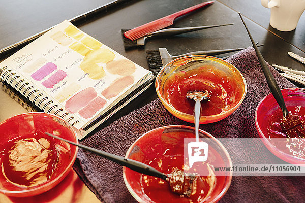 Pots of hair colour and a colour chart in a hair salon.