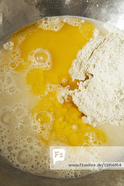 Nahaufnahme von Brotteig in einer metallenen Rührschüssel  Mehl  Wasser und Eiern.