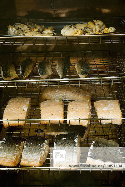 Fish fillets on racks in a fish smoker.