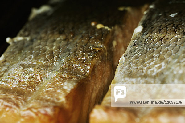 Close up of fish fillets on a rack in a fish smoker.