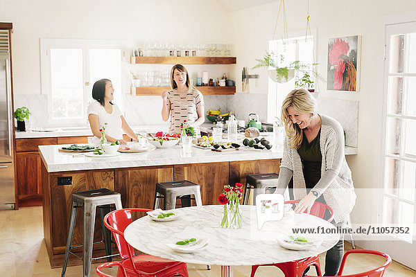Drei Frauen in einer Küche bei der Zubereitung des Mittagessens.