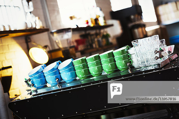 Spezialisiertes Kaffeehaus. Blaue und grüne Kaffeetassen gestapelt auf der Theke.