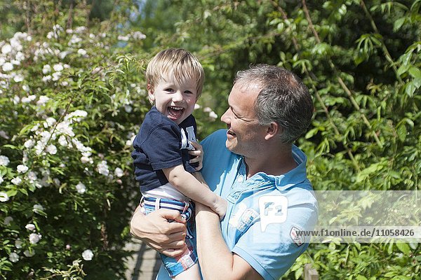 Junge  2 Jahre  breites Lachen  wird von Vater gehalten und gekitzelt  Niederlande  Europa