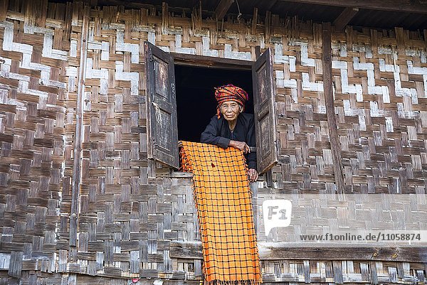 Old woman looking out of a lodge window mountain tribe or mountain people of the Pa-O or Pa-Oh or Pao or Black Karen or Taungthu or dew-soo ethnic minority near Kalaw Shan State Myanmar Asia