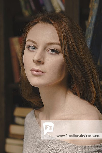 Young red-haired woman wearing a grey jumper  portrait