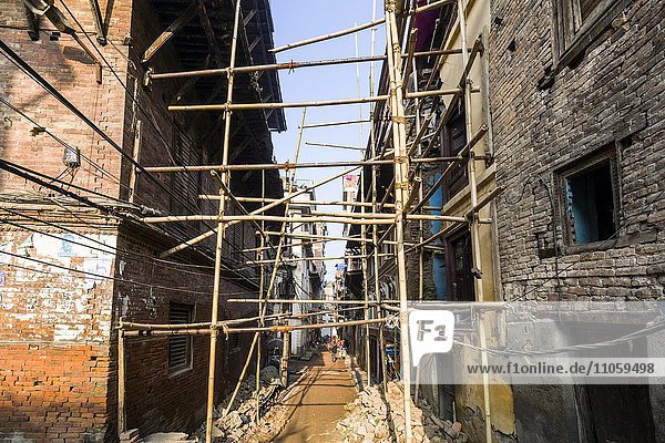 Beschädigte Häuser werden durch Bambusstangen stabilisiert  nach dem Erdbeben 2015  Kathmandu  Nepal  Asien