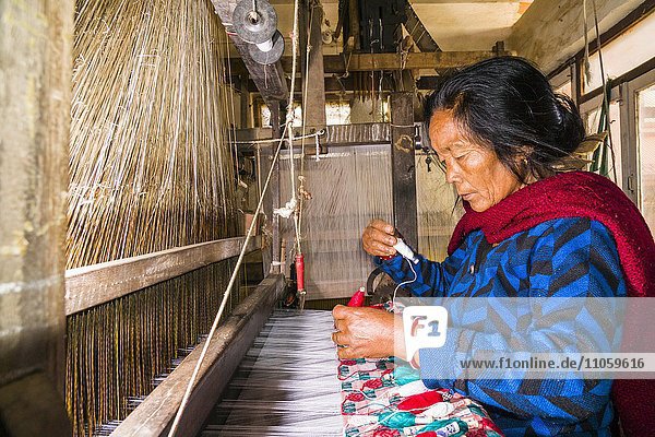 Eine Frau arbeitet an einem alten traditionellen Webstuhl und webt das Material für die nepalesischen Dhaka topi Hüte  Tansen  Palpa  Nepal  Asien