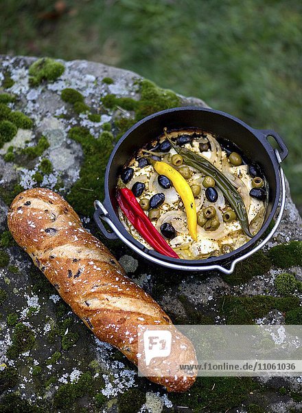 Dish with peppers  olives and feta cheese in a pot  bread