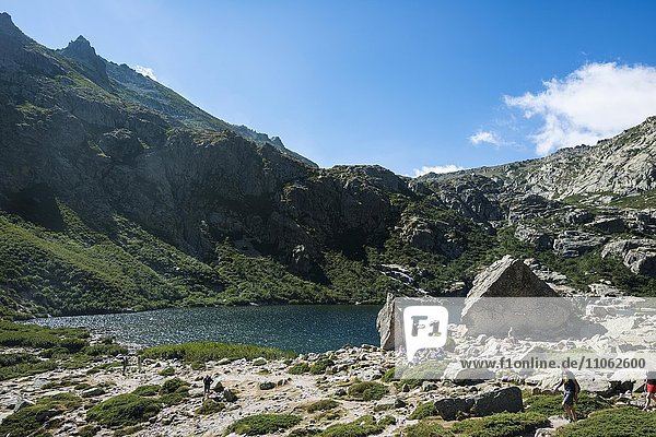 Wanderer am Bergsee Lac de Melo  Restonica Hochtal  Quelle des Restonica Fluss  Corte  Département Haute-Corse  Korsika  Frankreich  Europa