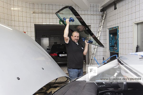 Wechseln  einsetzen der Frontscheibe an einem PKW in einer Kfz-Werkstatt für Autoglas  Düsseldorf  Nordrhein-Westfalen  Deutschland  Europa