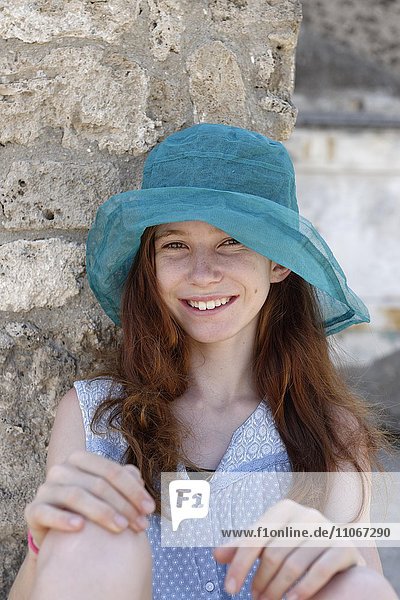 Red-haired girl with a turquoise sun hat smiling  portrait  Italy  Europe